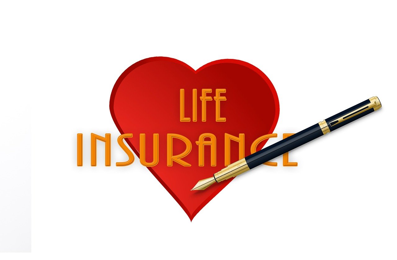 Red heart with the words life insurance and a pen across it